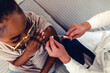 © Jelena Stanojkovic - Portrait of African-American young woman looking at while getting covid vaccine in clinic or hospital, with hand nurse injecting vaccine to get immunity for protect virus.