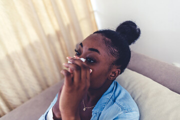 Beautiful young African-Amercian woman with eyesight problems.The face of pretty woman putting eye drops in her eyes to relief for her irritated eyes.