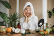 © sofiko14 - Close up view of face of young asian woman applying natural cosmetics at home, making homemade cream for skin, hair care at with exotic background in spa resort