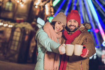 Poster - Photo of two lovely peaceful partners embrace hold hot chocolate cup enjoy garland lights x-mas evening outdoors