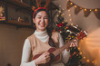 © butsaya33 - Portrait of young adult millennial Asian people singing playing guitar ukulele and having fun in living room celebrating Christmas eve together. Young people celebrating New Year at home party.