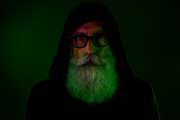 Wall Mural - Photo of clever mystic senior guy wear black hoodie arms eyewear isolated dark green color background