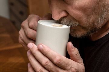 a man drinks cappuccino coffee close-up moustache in foam