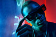 © ADDICTIVE STOCK - Cool black man in fashionable sunglasses in neon light