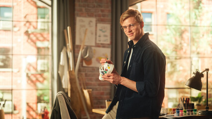 Leinwandbilder - Concentrated Male Artist Working on Colourful Bold Design of Sneakers in Loft Studio. Fashion Designer Customising Pair of Shoes with His Own Art And Looks Into Camera. New Generation Creatives.