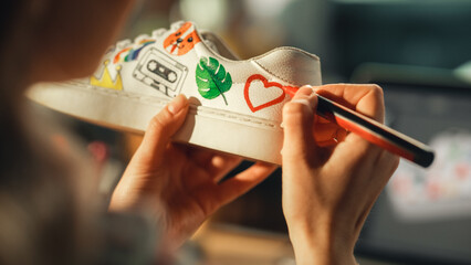 Leinwandbilder - Close Up Over the Shoulder View of Teen Female Artist Applying Colourful Brave Design on Sneakers, Spending Time at Home. Girl Using Computer with 3D Model of Footwear. Drawing on Shoes Concept.