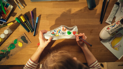 Leinwandbilder - Top View of Female Designer Creating Hand Made Shoes, Drawing on Them at Home. Woman Working in Creative Mess on the Table. Footwear Customising and Creative Occupation Concept. Close Up.