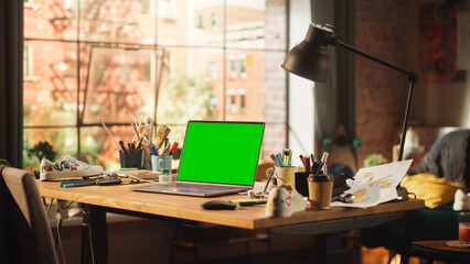 Poster - Laptop Computer with Mock Up Green Screen Chroma Key Display Standing on the Desk in the Modern Loft Workspace. Open Space Studio In the Background with City Window View.