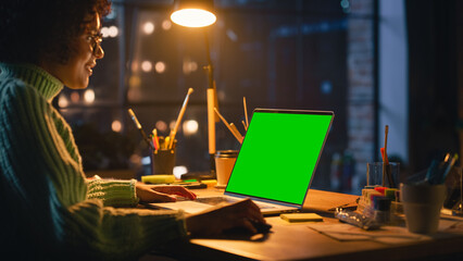 Poster - Positive Female Designer Working From Home on Laptop Computer with Green Screen Chromakey on Display. Woman Using Computer Mouse, Thinking About New Project. Freelance and Millennial People Concept.