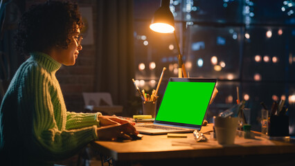 Poster - Positive Female Designer Working From Home on Laptop Computer with Green Screen Chromakey on Display. Woman Using Computer Mouse, Thinking About New Project. Freelance and Millennial People.