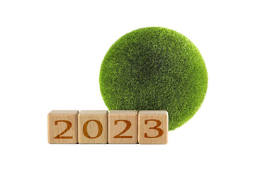 2023 is a good year for the growth of environmental business. The grass grows in the shape of a globe. The inscription 2023 on wooden cubes and a globe-shaped ball of grass