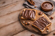 © iloli - Board of bread with chocolate paste and hazelnuts on wooden background