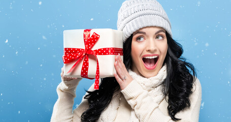 Wall Mural - Young woman holding a Christmas gift box