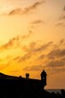 Silhouettes of people near the walls of El Morro Fort at golden sunset, old San Juan, Puerto Rico