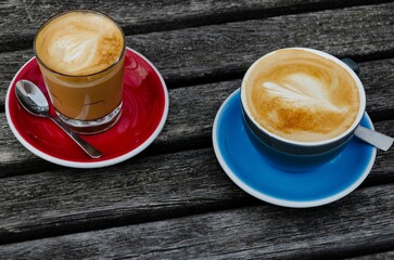 Sticker - Top view of two cups of coffee on wooden background