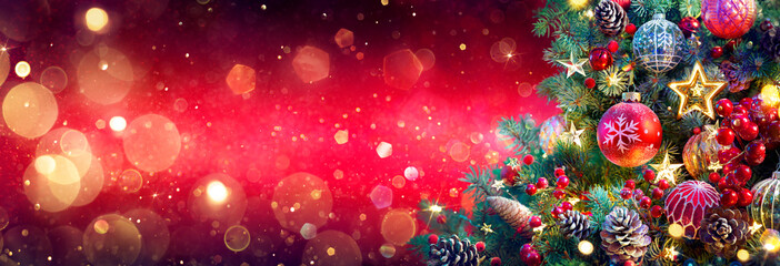 Wall Mural - christmas tree in red shiny background - ornaments on fir branches with glittering and defocused abs