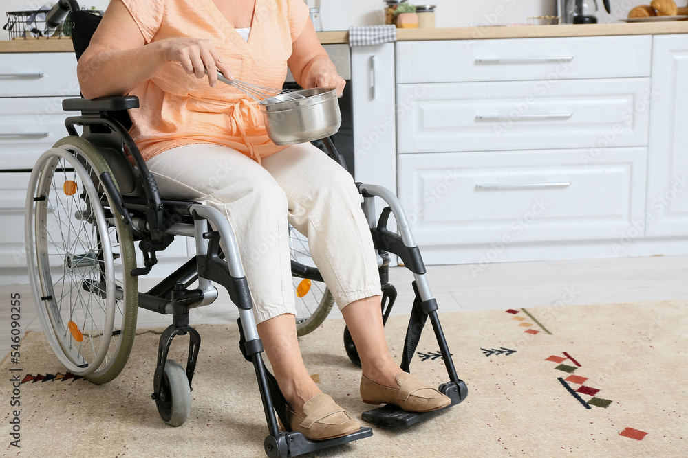 Mature woman with physical disability cooking in kitchen