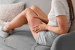 © Pixel-Shot - Young woman with bruised leg sitting on sofa at home