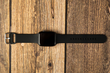 Modern smart watches are multifunctional. Clock on a wooden background.