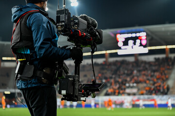 cameraman behind playing field during soccer match.