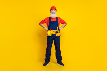 Poster - Full length photo of positive confident age man wear overall uniform red hard hat arms waist isolated yellow color background