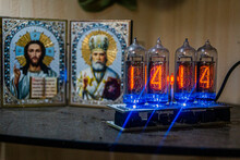 Colored Lamp Clock Stands Against The Background Of The Icons Of Jesus Christ And St. Nicholas The Wonderworker	
