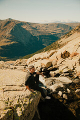 Sticker - Boy looking at an impressive mountain landscape from the top