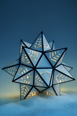 Wall Mural - Close up shining paper star in cold snow