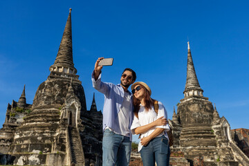 Couple of foreign tourists take selfie photo at Wat Phra Si Sanphet temple, Ayutthaya Thailand, for travel, vacation, holiday, honeymoon and tourism concept