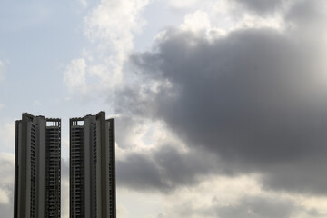 Wall Mural - Tall towers of a high rise skyscraper with a background of a cloudy monsoon sky.