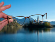 Glasses. Monastery on the water seen through eyeglass lenses. Lake Bled