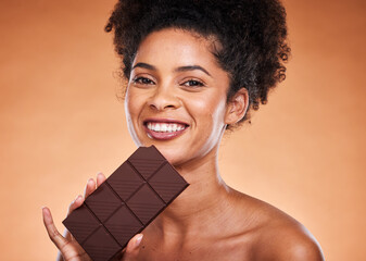 Wall Mural - Chocolate, happy woman and beauty portrait on studio background eating sweets, dessert or sugar. Young african american girl bite dark chocolate bar and cocoa candy, calories and delicious food snack