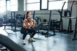 © yurolaitsalbert - fitness woman performing squat exercises with dumbbells.