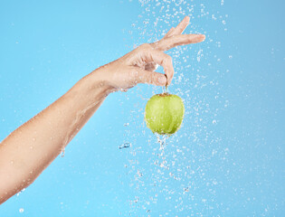 Canvas Print - Apple, water and hand with fruit hanging for vitamin healthcare or nutrition sustainability in studio. Healthy body wellness, detox health and healthy food under water in blue studio background