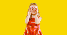 Portrait Of Happy Cheerful Little Girl Having Fun On Yellow Background