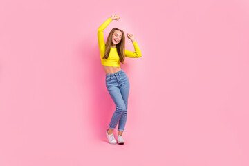 Wall Mural - Full length photo of excited dreamy school girl dressed yellow crop top dancing closed eyes isolated pink color background