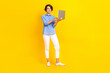 Leinwandbild Motiv Full size photo of adorable gorgeous woman with bob hairdo dressed blue shirt hold laptop remote job isolated on yellow color background