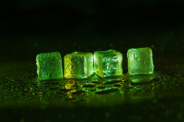 Wall Mural - Green ice cubes on black background.