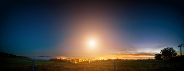 Poster - full moon low over the horizon in the early morning over the city