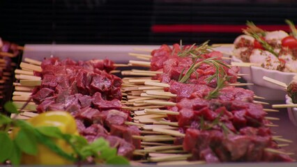 Wall Mural - Selling chops of beef meat on skewers layout in the store. Selection of different cuts of fresh meat raw red in a supermarket.