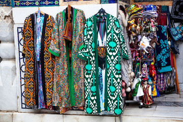 Uzbek traditional clothes such as robes and other colorful souvenirs, Tashkent, Uzbekistan. 