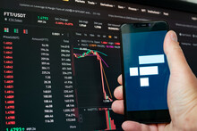 Man Holding Phone With FTX Logo. Global Fall Of Cryptocurrency Graph - FTT Token Fell Down On The Chart Crypto Exchanges On App Screen. FTX Exchange Bankruptcy And The Collapse Depreciation Of Token
