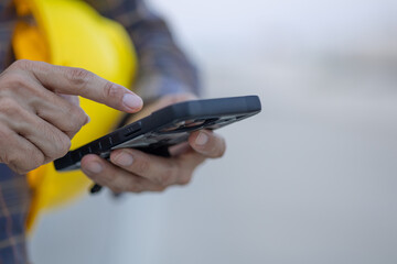 close up construction worker hands touch screen using smartphone