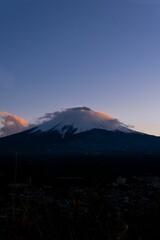 Poster - Fuji mountain with a snow cap surrounded by the white clouds during sunset in Japan