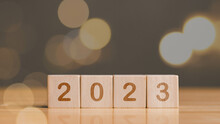 Happy New Year 2023, Horizontal Wood Blocks Cube Or Square With Number 2023 On Wood Table, Flair Light Background. New Year 2023 Concept.