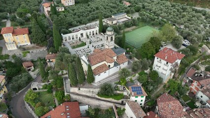 Wall Mural - Aerial footage of the city of Nago-Torbole in Trentino, Italy, with an old cathedral