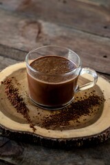 Sticker - Vertical high angle shot of dark chocolate milkshake in a  glass mug on wooden surface