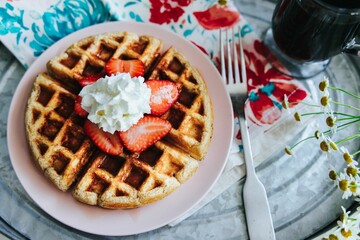 Canvas Print - High angle shot of strawberry waffles and coffee in a tray