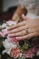 Canvas Print - Selective focus of a bride's hands with a promise ring on the background of a bridal bouquet