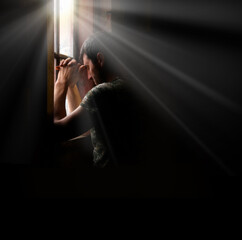 sad soldier praying at the window